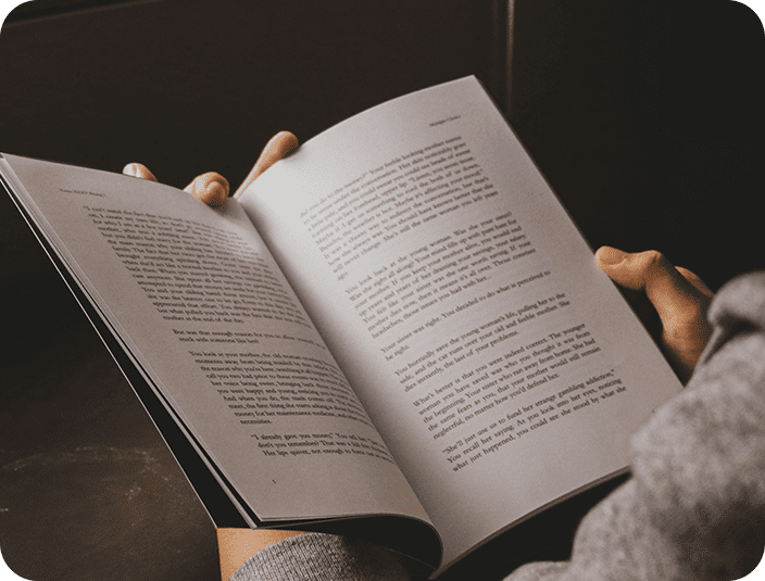 A person reading an open book in their hands.