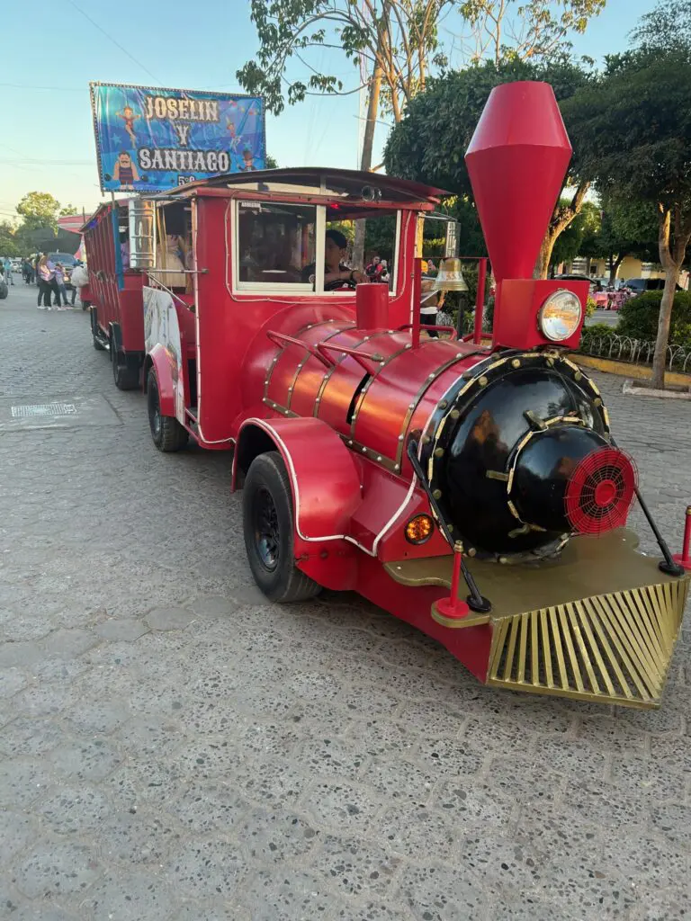 A red train is parked on the street.