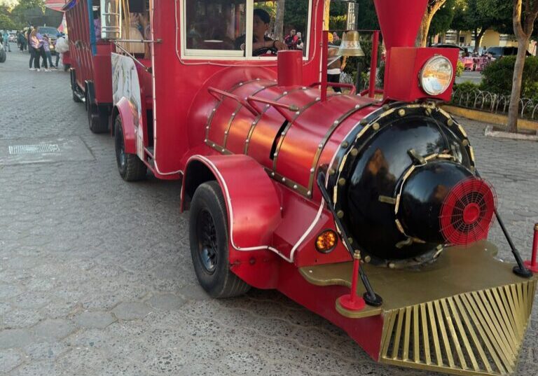 A red train is parked on the street.