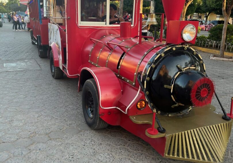 A red train is parked on the street.