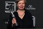 Woman holding an award at an event.